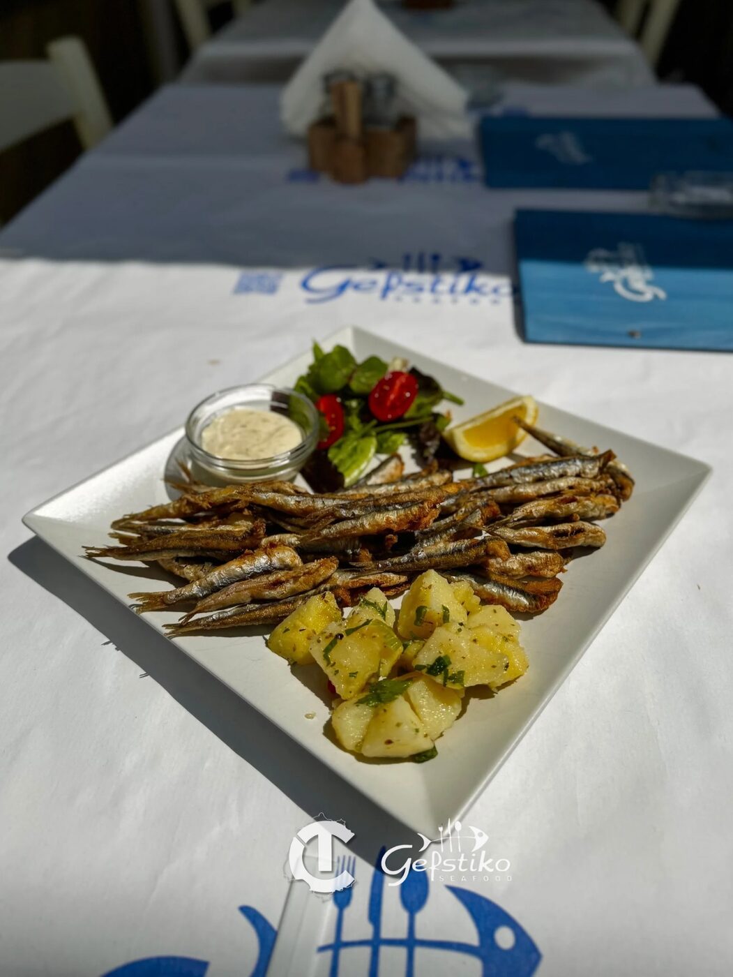 Harbour-side terrace tables set for lunch at Gefstiko